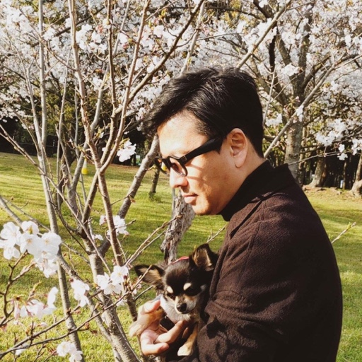 犬を抱くシュ コウメイの横顔